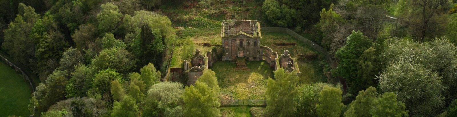bird's eye view of a derelict building surrounded by trees