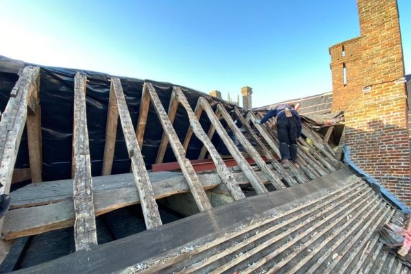A timber frame roof being repaired