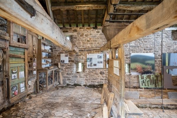 The interior of the Beast House in Wales, with wooden ceiling beams and interpretation panels.