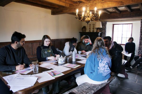 A group of people sat around a table filled with paper