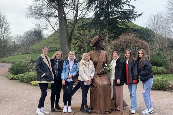 A group of people standing next to a statue