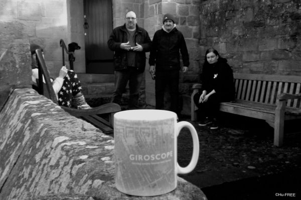 black and white image of people standing outside a castle wall