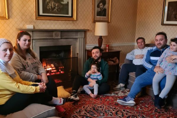 Children and adults sitting round a fireplace