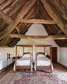 A twin bedroom with a timber beamed celing