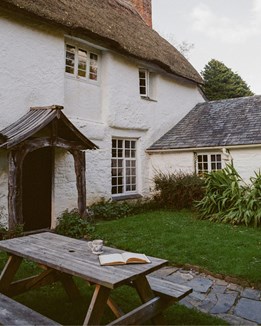 A white cottage with a thatched roof