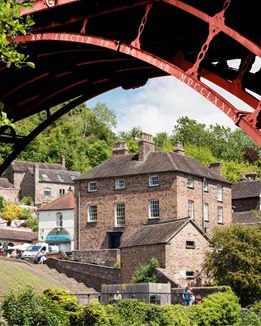 Georgian house on a hillside near a red bridge
