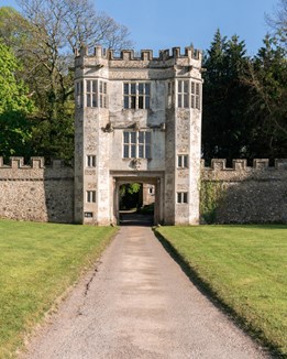 A folly with two towers overlooking a green