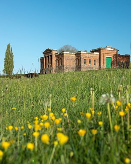 A large Victorian stable block surrounded by fields