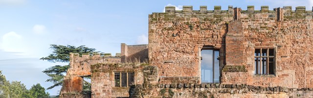 A section of a converted castle with crenellations and large glazed windows