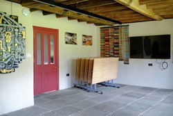 Calverley Old Hall Community Space TV end with chairs stacked angle 1200x800