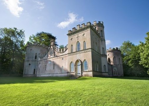 A grey castle surrounded by trees