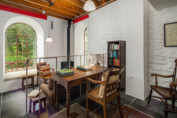 A wooden table covered in books looking out onto a large window