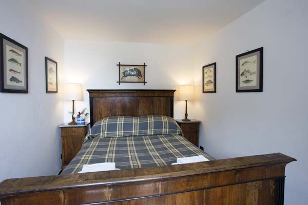 Double bedroom with blue checked cover and wooden head and foot boards