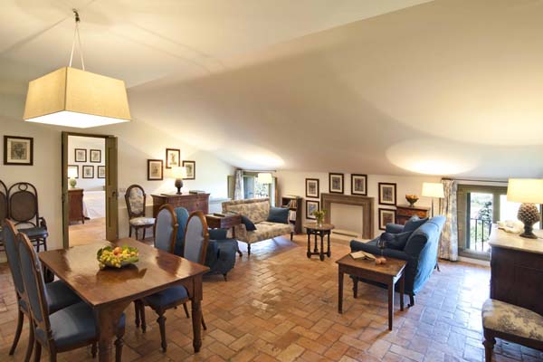 Sitting room with polished sandstone floor and low windows with low sloping roof