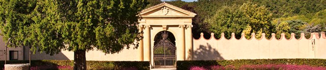 Yellow stone arched gateway surrounded by trees