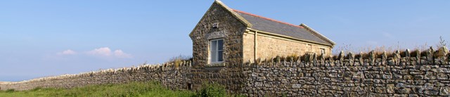 Old-Light-Cottage-exterior-main-with-wall-1600x345