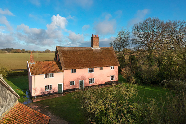 Manor Farm, a pale pink building with small annex and red brick chimney pots.