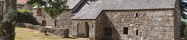A dartmoor longhouse in front of a green