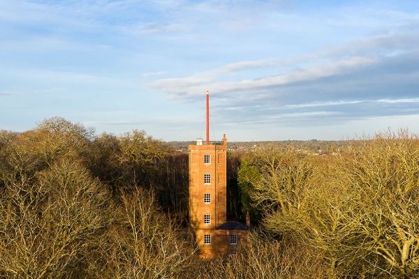 Aerial view of red-bricked Semaphore Tower surrounded by the woodland of Chatley Heath nature reserve