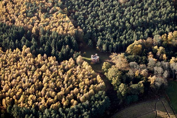 Drone view over Queen Anne's Summerhouse, a red brick four-towered little building surrounded by woodland