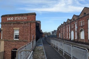 A train station platform next to a red brick building